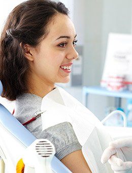 Healthy woman smiling at her dentist sitting in the dental chair