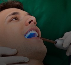Dentist shining a light into the mouth of a patient