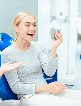 A woman admiring the results of recent cosmetic dentistry