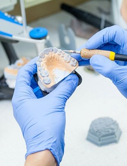 Lab technician working on set of dentures