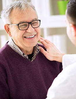Older male patient smiling at his Murphy implant dentist 