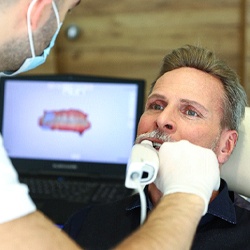 Dentist using digital impression scanner to design dental implant restorations