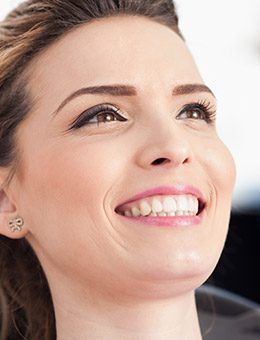 Woman smiling up at dentist after periodontal therapy
