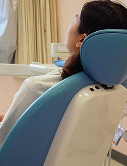 Woman resting in dental exam chair under IV sedation dentistry