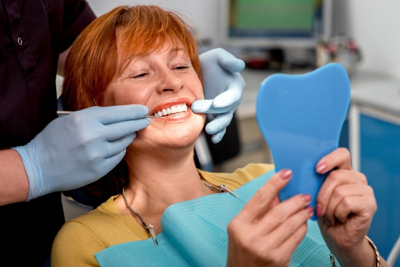 An older woman getting a checkup with her dentures